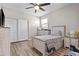 Bedroom with wood-look floors, a ceiling fan, and dresser, closet, and bed in the center of the room at 3529 N Brooklyn Dr, Buckeye, AZ 85396