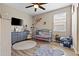 Bright, neutral Bedroom featuring a crib, dresser, and area rugs on the wood-look floors with a ceiling fan at 3529 N Brooklyn Dr, Buckeye, AZ 85396