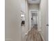 Hallway with wood-look flooring leading to open rooms and a view of the living area in the background at 3529 N Brooklyn Dr, Buckeye, AZ 85396