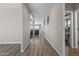 Hallway featuring neutral colored walls and wood floors leading to the living room with a ceiling fan at 3529 N Brooklyn Dr, Buckeye, AZ 85396