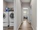 Bright laundry room with washer and dryer and storage shelves and wood-look flooring at 3529 N Brooklyn Dr, Buckeye, AZ 85396
