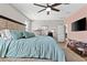 Inviting main bedroom with a ceiling fan, a workspace, and ample natural light and wood-look flooring at 3529 N Brooklyn Dr, Buckeye, AZ 85396