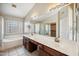 The main bathroom features dual sinks, vanity, soaking tub, glass shower, and ample natural light at 3905 S Bridal Vail Dr, Gilbert, AZ 85297