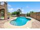 Inviting backyard pool with a brick patio, mature trees, and clear blue sky, perfect for outdoor relaxation and entertaining at 3905 S Bridal Vail Dr, Gilbert, AZ 85297