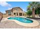 Spacious backyard with a refreshing pool, lush landscaping, and a charming two-story home with an upper balcony at 3905 S Bridal Vail Dr, Gilbert, AZ 85297