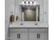 Bright bathroom with a double sink vanity, framed mirror, and updated fixtures at 40445 W Bravo Dr, Maricopa, AZ 85138