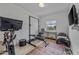 Bright home gym featuring workout equipment, a TV, and natural light from a window at 40445 W Bravo Dr, Maricopa, AZ 85138