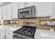 This kitchen features stainless steel appliances, white cabinets, and a tile backsplash at 4121 E Patrick St, Gilbert, AZ 85295