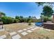 Spacious backyard featuring an above-ground pool, lush greenery, and stepping stones at 4443 W Escuda Dr, Glendale, AZ 85308