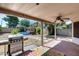 Covered patio with a grill overlooking a backyard with an above-ground pool and greenery at 4443 W Escuda Dr, Glendale, AZ 85308