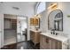 A bright bathroom with double vanity, modern lighting, and a large closet at 4443 W Escuda Dr, Glendale, AZ 85308