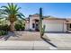 Inviting single-story home with desert landscaping, mature palm tree, and private two-car garage at 4443 W Escuda Dr, Glendale, AZ 85308