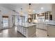 Bright open kitchen with large island, stainless steel appliances, and stylish pendant lighting at 4443 W Escuda Dr, Glendale, AZ 85308