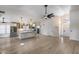 Open-concept living room and kitchen featuring white cabinets and a large central island at 4443 W Escuda Dr, Glendale, AZ 85308