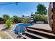 Backyard plunge pool with wood deck, steps, cover, patio umbrella, and desert landscaping at 4443 W Escuda Dr, Glendale, AZ 85308