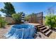 Backyard plunge pool with wood deck, privacy screen, striped umbrella, and desert landscaping at 4443 W Escuda Dr, Glendale, AZ 85308