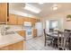 Cozy eat-in kitchen features wood cabinets, white appliances, and tile flooring at 4501 E Carol Ave # 77, Mesa, AZ 85206
