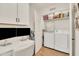 Bright laundry room featuring a workspace with dual monitors, overhead cabinets, and modern washer and dryer at 5450 E Deer Valley Dr # 1004, Phoenix, AZ 85054