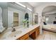 Bathroom with double sinks, wood cabinets and tile floor that connects to bedroom at 5710 E Anderson Dr, Scottsdale, AZ 85254