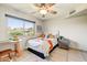 Cozy bedroom features a ceiling fan, large window and comfortable furnishings at 5710 E Anderson Dr, Scottsdale, AZ 85254