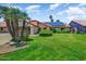 Inviting single-story home featuring a lush lawn, mature palm trees, and solar panels at 5710 E Anderson Dr, Scottsdale, AZ 85254