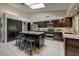 Well-designed kitchen featuring dark cabinetry, stainless steel appliances, a center island with seating, and tile floors at 5710 E Anderson Dr, Scottsdale, AZ 85254