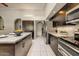 Modern kitchen with stainless steel appliances, dark wood cabinets, and granite countertops at 5710 E Anderson Dr, Scottsdale, AZ 85254