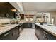 Modern kitchen featuring dark wood cabinets, stainless steel appliances, and tile flooring at 5710 E Anderson Dr, Scottsdale, AZ 85254