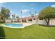 Inviting backyard showcasing a sparkling pool, lush artificial turf, and mature landscaping, perfect for outdoor living at 7049 E Latham St, Scottsdale, AZ 85257