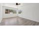A bright bedroom with wood flooring, white walls, and windows with colorful outdoor views at 7049 E Latham St, Scottsdale, AZ 85257