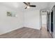 A bright bedroom with wood flooring, white walls, ceiling fan and access to another room at 7049 E Latham St, Scottsdale, AZ 85257