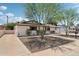Side view of home featuring low maintenance landscaping, lush trees, and attached covered parking at 7049 E Latham St, Scottsdale, AZ 85257