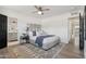 Bright main bedroom features an upholstered headboard, ceiling fan, and doorway to bathroom at 7049 E Latham St, Scottsdale, AZ 85257
