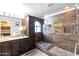 Modern bathroom with walk-in shower, dark wood cabinets, and arched window at 7140 E Juanita Ave, Mesa, AZ 85209