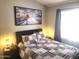 Inviting bedroom showcasing a patterned comforter, window, and decorative lighting at 7140 E Juanita Ave, Mesa, AZ 85209