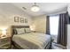 Cozy bedroom boasts a queen bed, stylish light fixture, and modern decor at 7140 E Juanita Ave, Mesa, AZ 85209