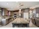 Open kitchen boasts stone countertops, tiled backsplash, stainless appliances and an eat-in island at 7925 E Osage Ave, Mesa, AZ 85212