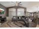 Spacious living room features a ceiling fan, a large sectional sofa, and custom window shutters at 7925 E Osage Ave, Mesa, AZ 85212