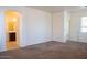 Spacious bedroom with neutral carpeting, bright natural light, and arched doorway to bathroom at 9025 W Crown King Rd, Tolleson, AZ 85353