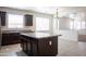 Kitchen island featuring dark wood cabinets, granite countertops, and tile flooring at 9025 W Crown King Rd, Tolleson, AZ 85353