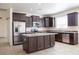Bright kitchen with stainless appliances, granite countertops, an island, and ample cabinet space at 9025 W Crown King Rd, Tolleson, AZ 85353