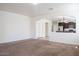 Open-concept living room with neutral carpet flowing into kitchen featuring granite counters at 9025 W Crown King Rd, Tolleson, AZ 85353
