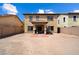 Exterior shot of a tan house with a spacious dirt backyard, patio, and privacy fence at 973 E Corral St, Avondale, AZ 85323