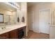 Bright bathroom with double sinks, vanity space, tile flooring, glass shower and white doors at 973 E Corral St, Avondale, AZ 85323