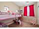 Small bedroom with a bunk bed, pink accents, rocking chair, and carpet flooring at 973 E Corral St, Avondale, AZ 85323