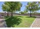 Expansive backyard with lush lawn, mature trees, and privacy fencing, perfect for outdoor activities at 1021 S Almar Cir, Mesa, AZ 85204