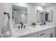 Bathroom featuring double sinks with black faucets and white countertops, complemented by modern mirrors and lighting at 1021 S Almar Cir, Mesa, AZ 85204