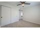 This bedroom features a ceiling fan and a spacious closet at 1021 S Almar Cir, Mesa, AZ 85204