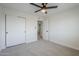 This bedroom has carpet, neutral walls, ceiling fan, and a view to another room at 1021 S Almar Cir, Mesa, AZ 85204