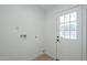 Bright laundry room with a utility sink and a door that leads to the backyard and swimming pool area at 1021 S Almar Cir, Mesa, AZ 85204